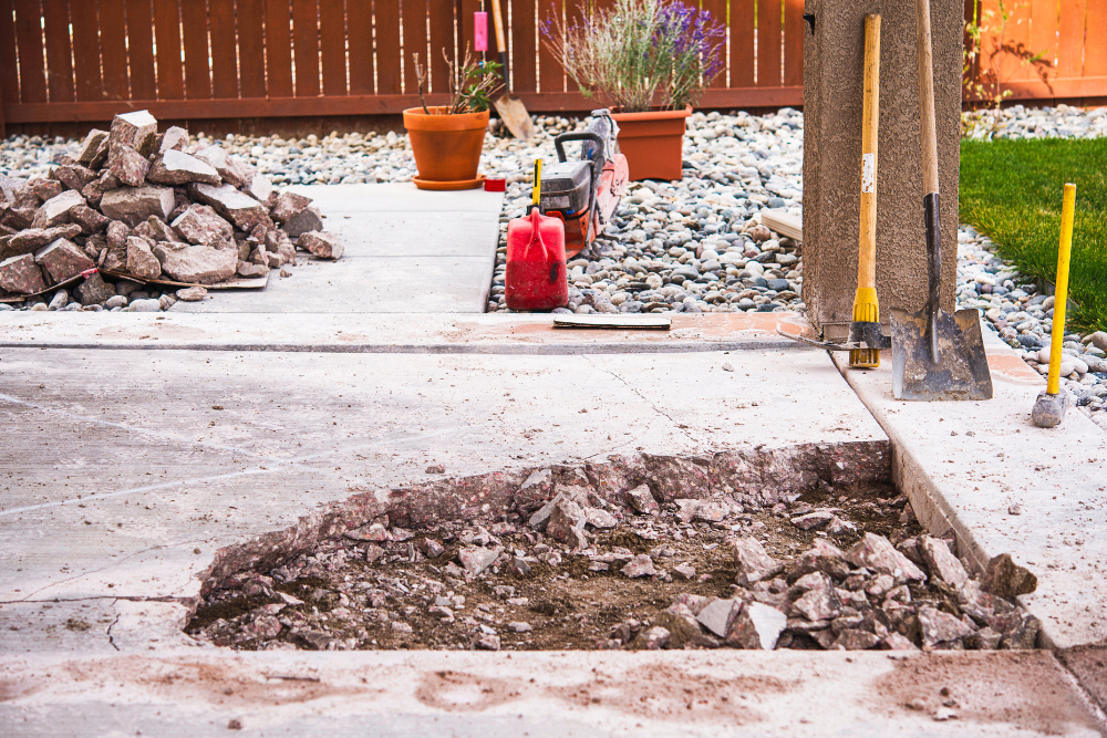 A concrete patio is being remodeled with tools and a red gas can