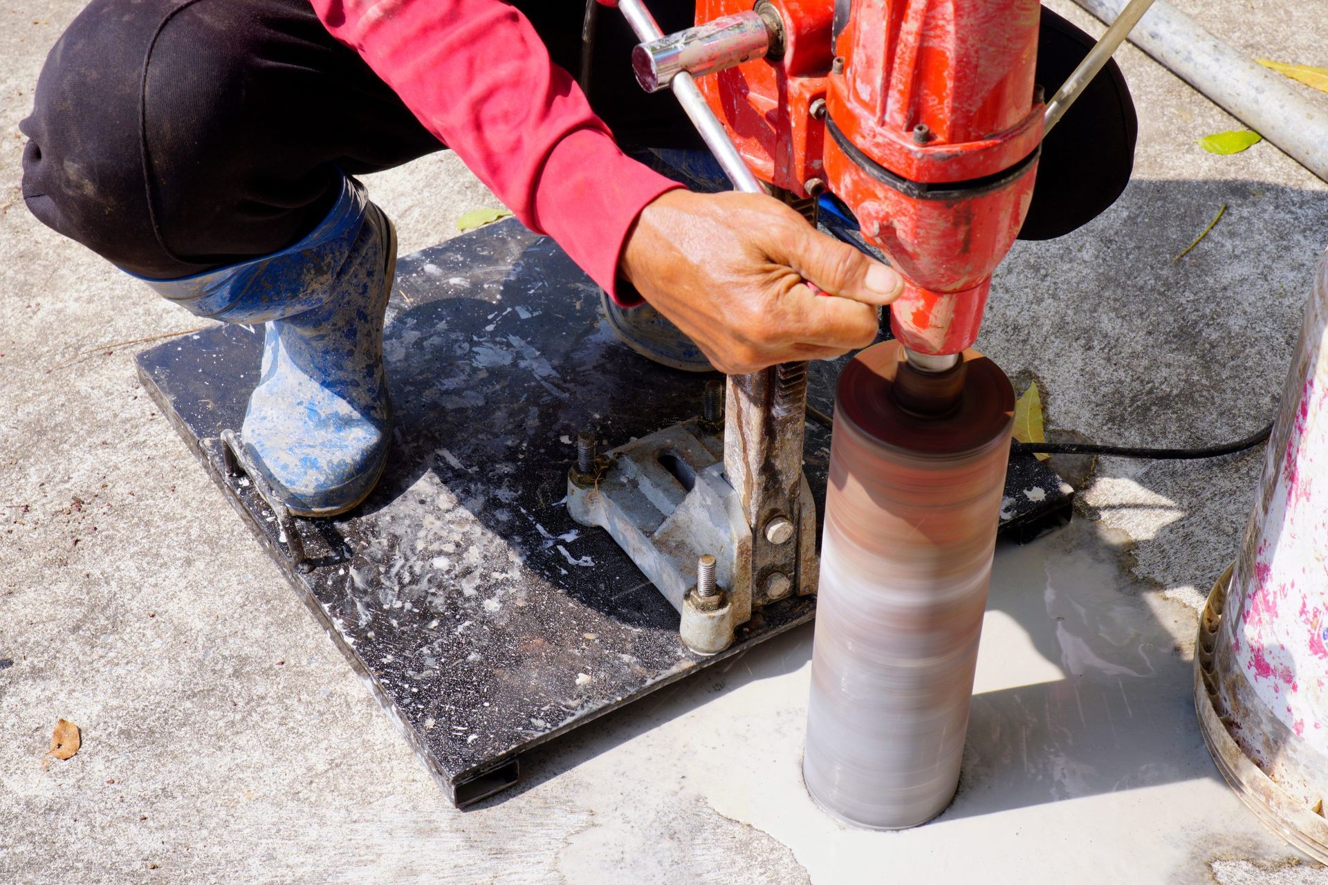 A construction worker is kneeling down on the ground.
