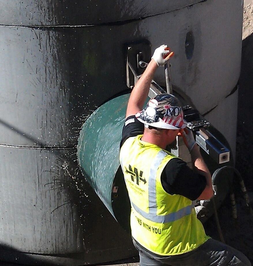 A man wearing a hard hat and a yellow vest that says ' i work with you ' on the back
