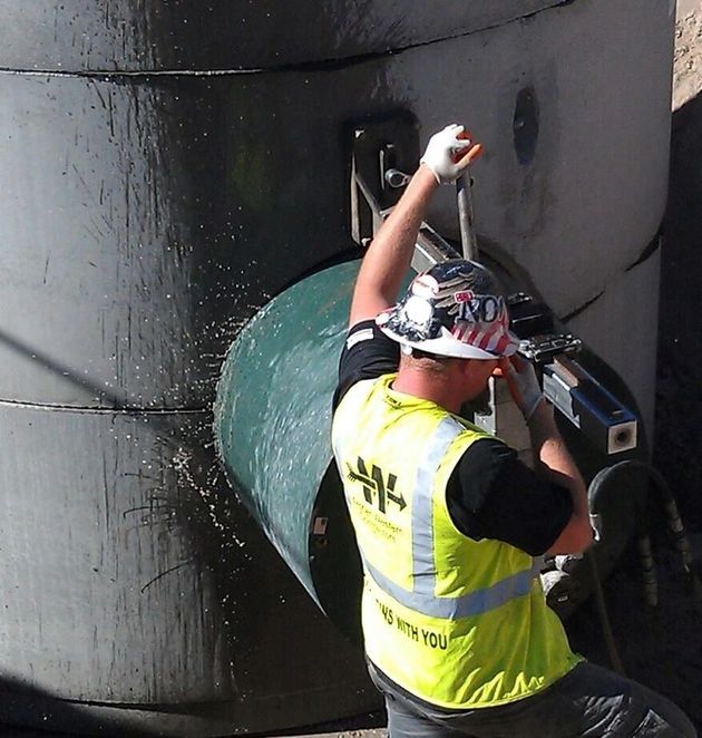 A man is using a circular saw to cut a piece of concrete