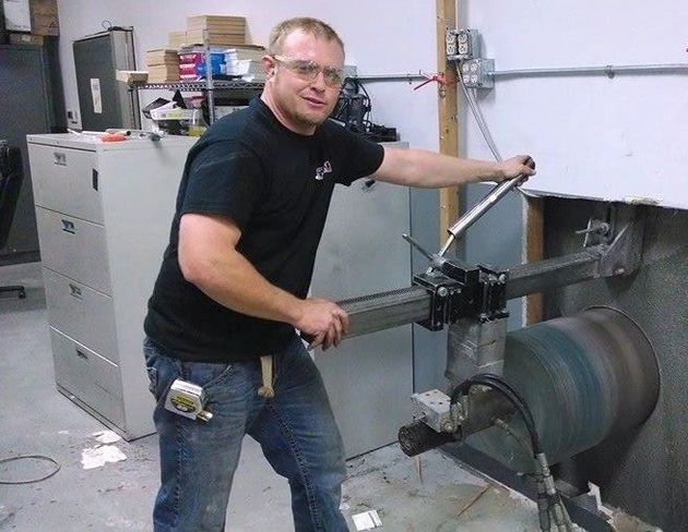 A man is using a circular saw to cut a piece of concrete
