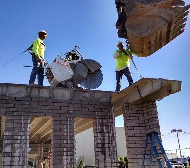 Two construction workers standing on top of a brick building
