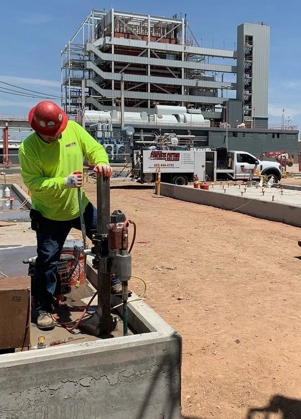 A construction worker is working on a machine on a construction site.