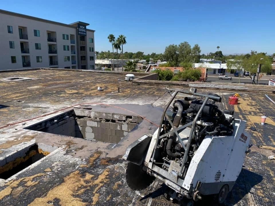 A machine is cutting a hole in the roof of a building.