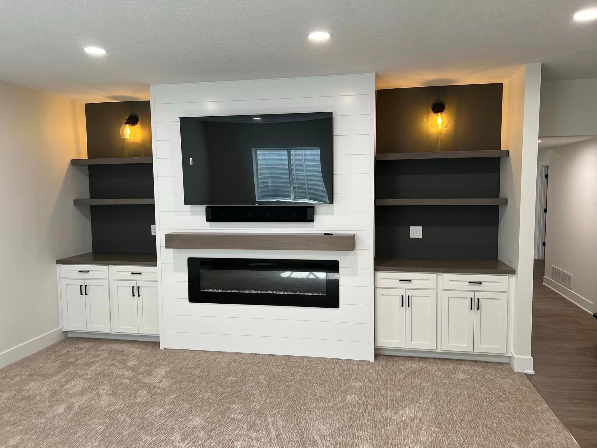 A living room with a fireplace and a flat screen tv on the wall.