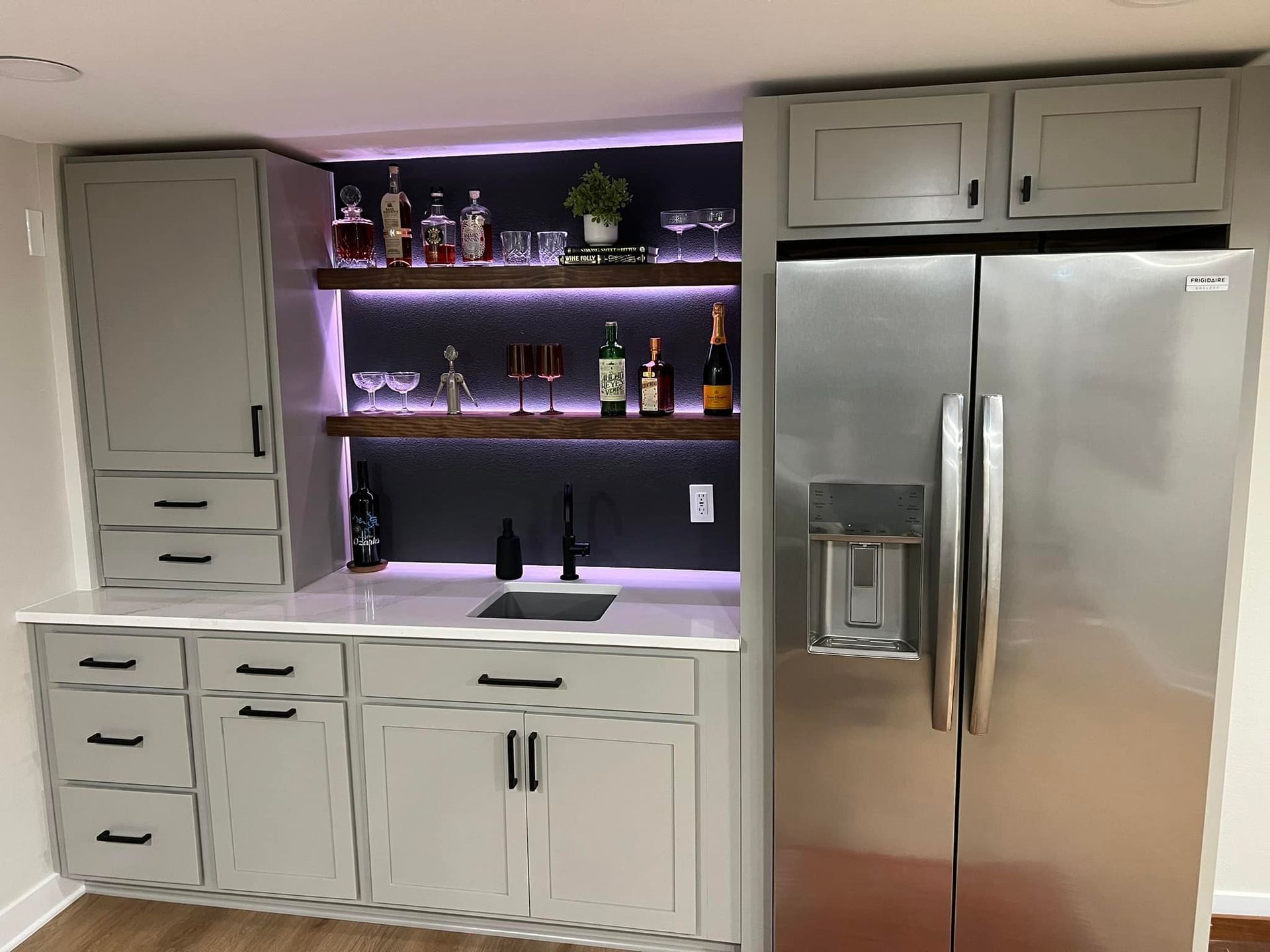 A kitchen with a stainless steel refrigerator and a sink