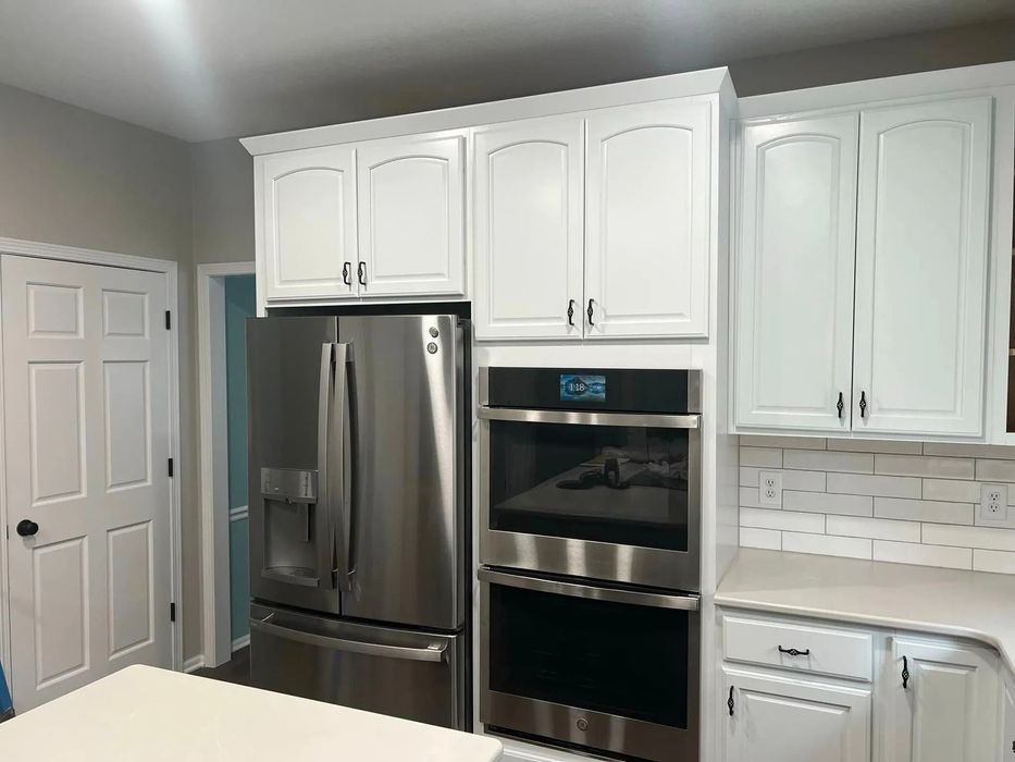 A kitchen with white cabinets and stainless steel appliances.