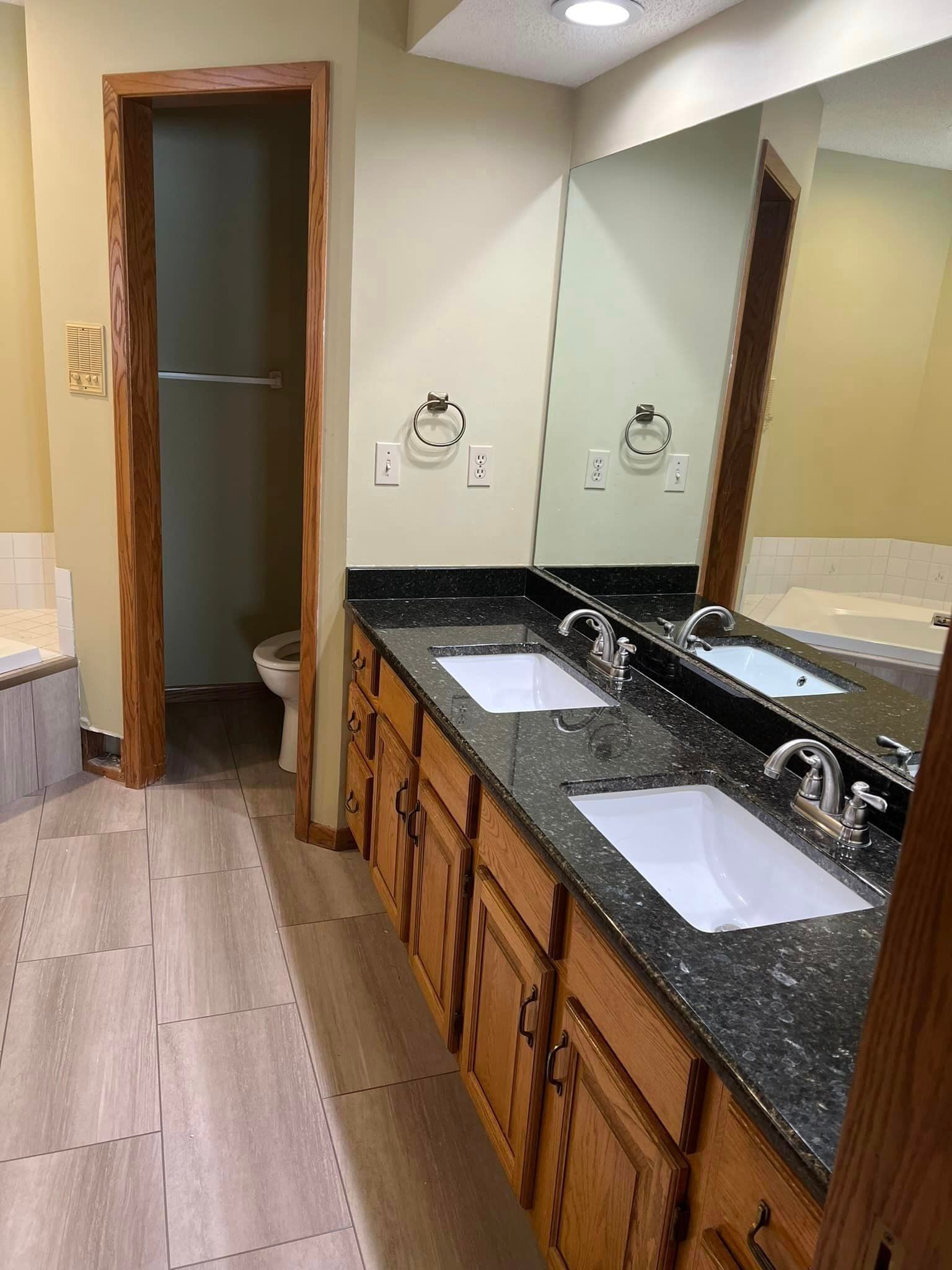 A bathroom with two sinks and a large mirror.