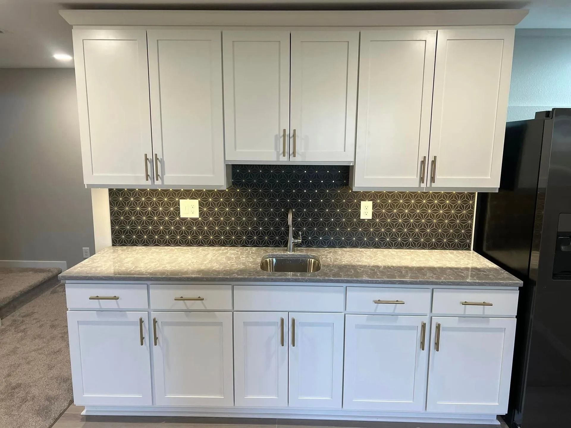 A kitchen with white cabinets and granite counter tops