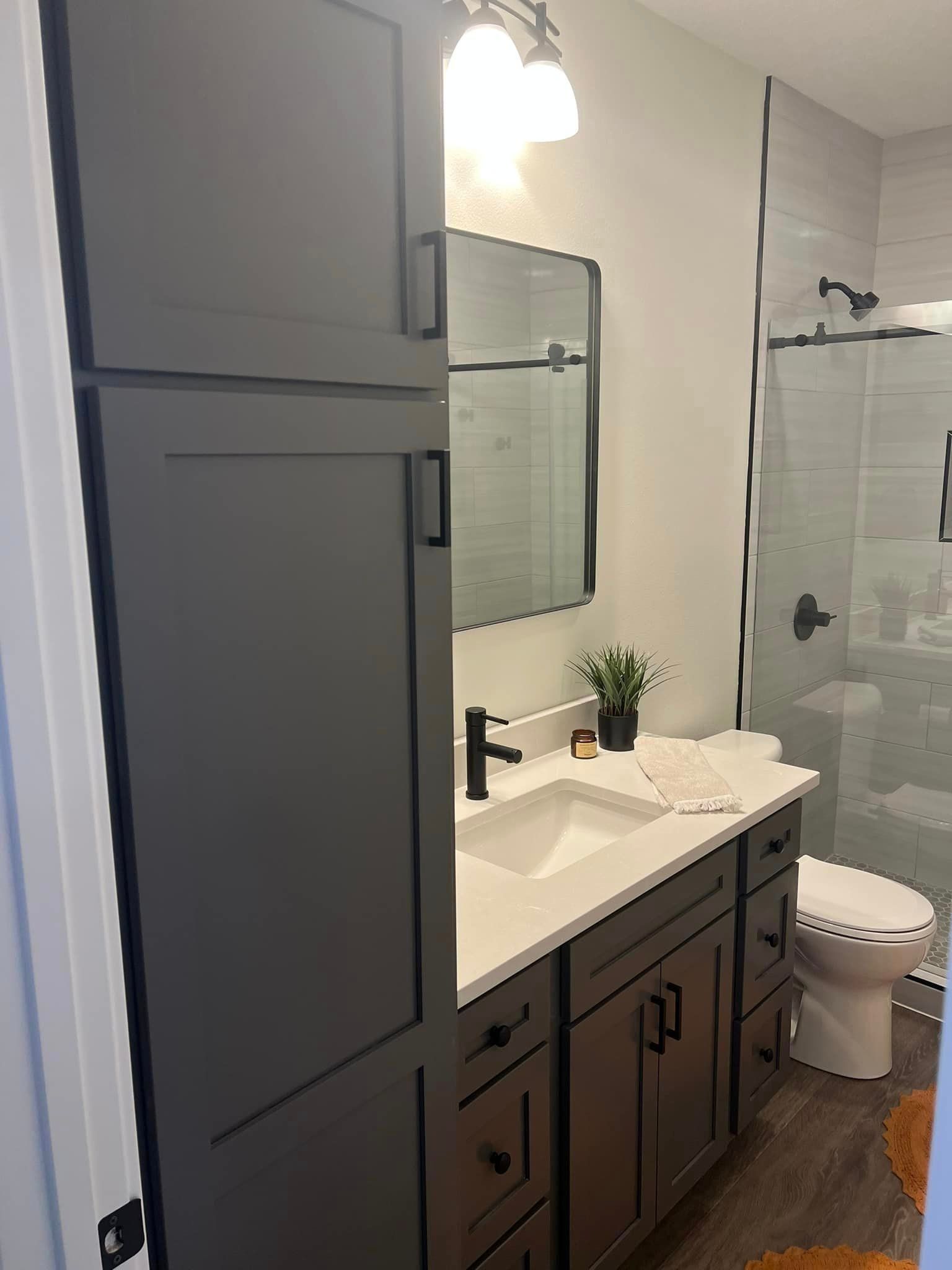 A bathroom with a sink , toilet and shower.