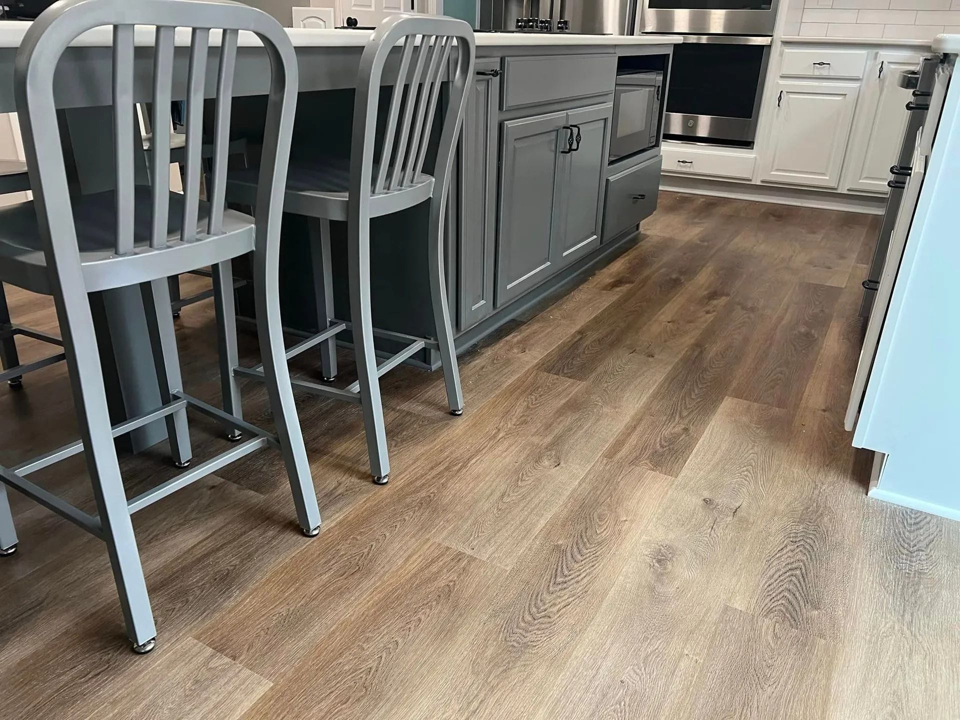 A kitchen with a wooden floor and a table and chairs.