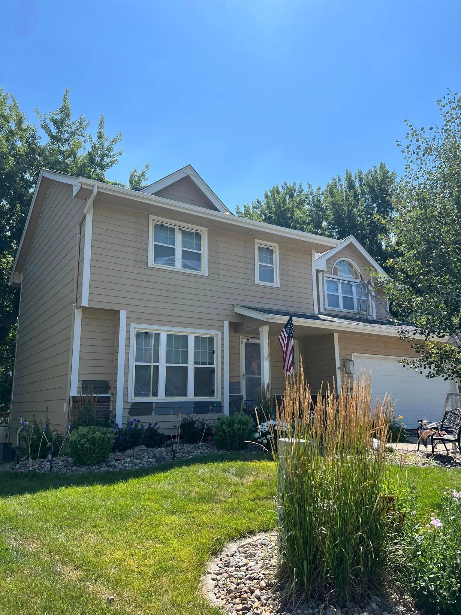 A large house with a lot of windows and a flag on the front porch.