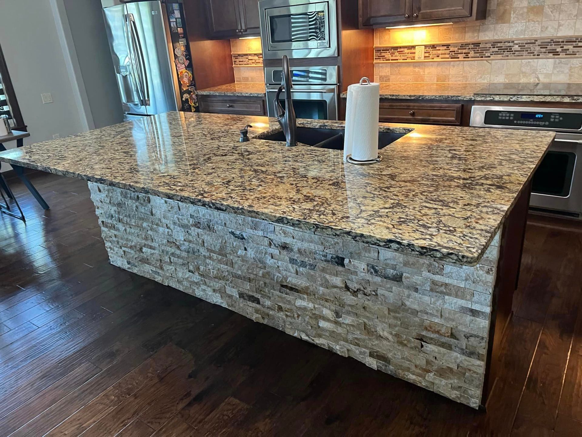 A kitchen with a large granite counter top and a sink.