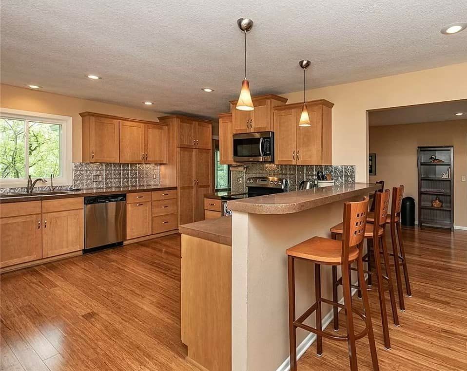 A kitchen with hardwood floors and stainless steel appliances