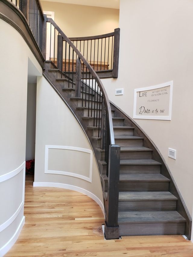 a curved staircase with a metal railing in a house