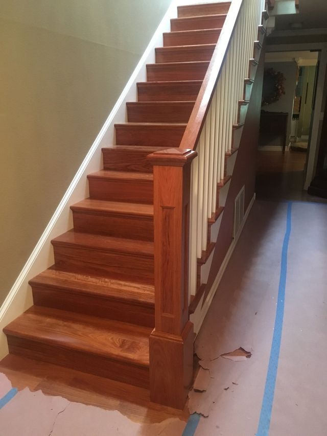 a wooden staircase with a white railing in a room .