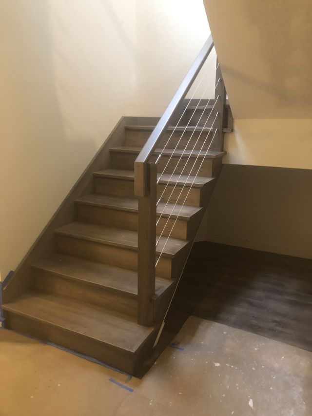 a wooden staircase with a metal railing in a room .