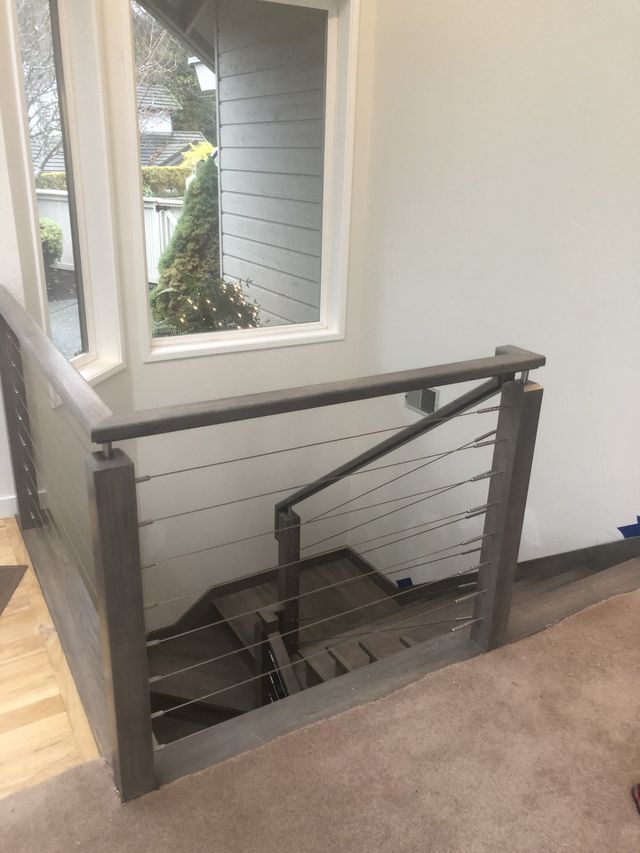 a staircase with a stainless steel railing and a window .