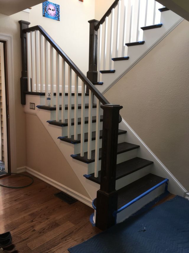 a staircase with a white railing and black steps