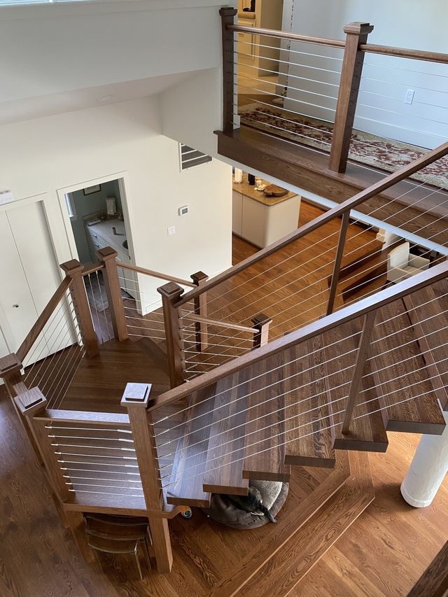 an aerial view of a wooden staircase with a stainless steel railing .