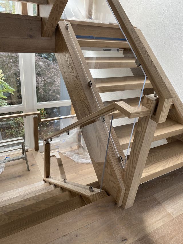 a wooden staircase with a glass railing in a house .