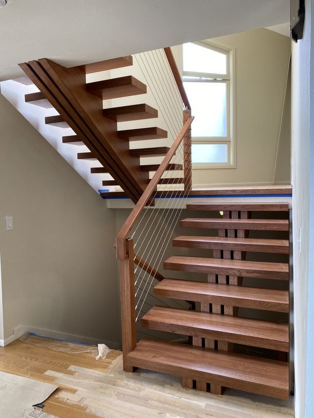 a wooden staircase with a wire railing in a house