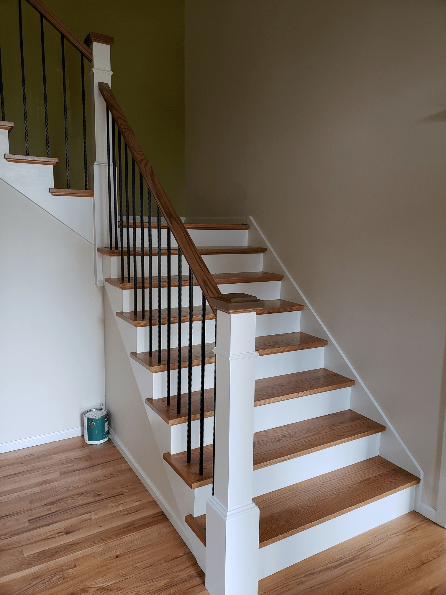 a staircase with wooden steps and white railings in a room .