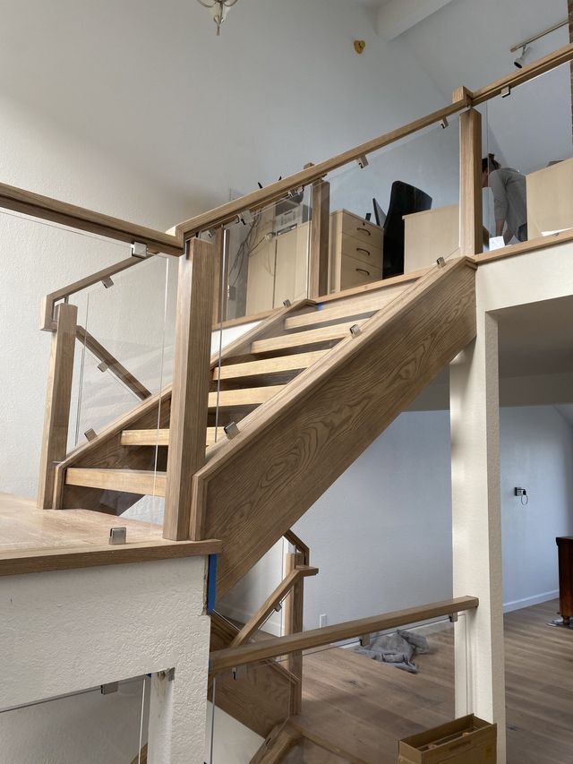 a wooden staircase with a glass railing in a house .
