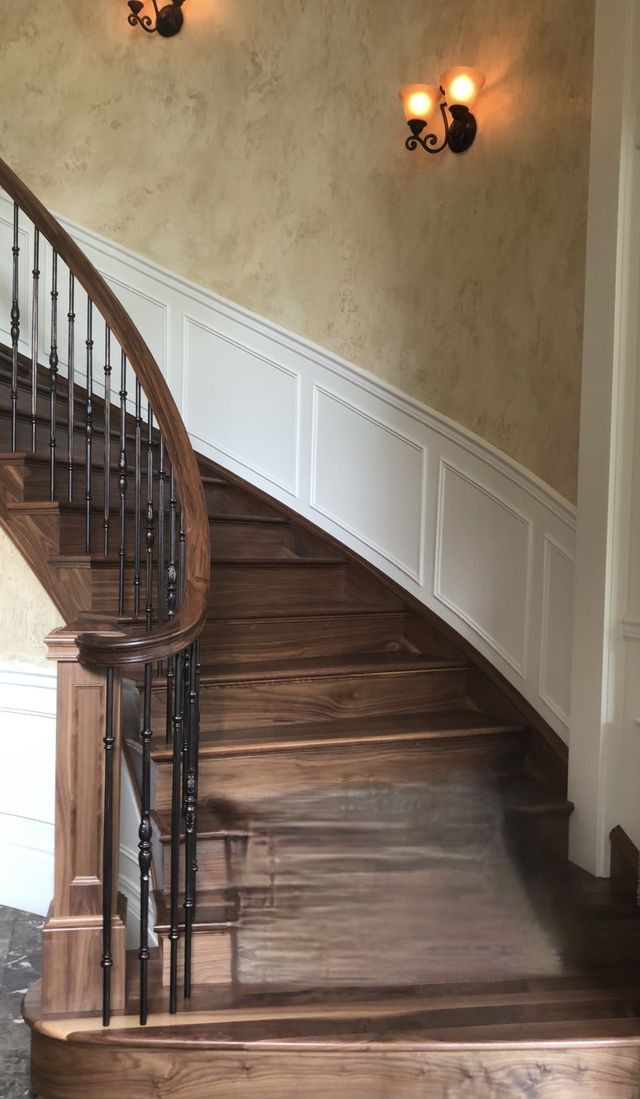 a wooden staircase with a wrought iron railing in a house .