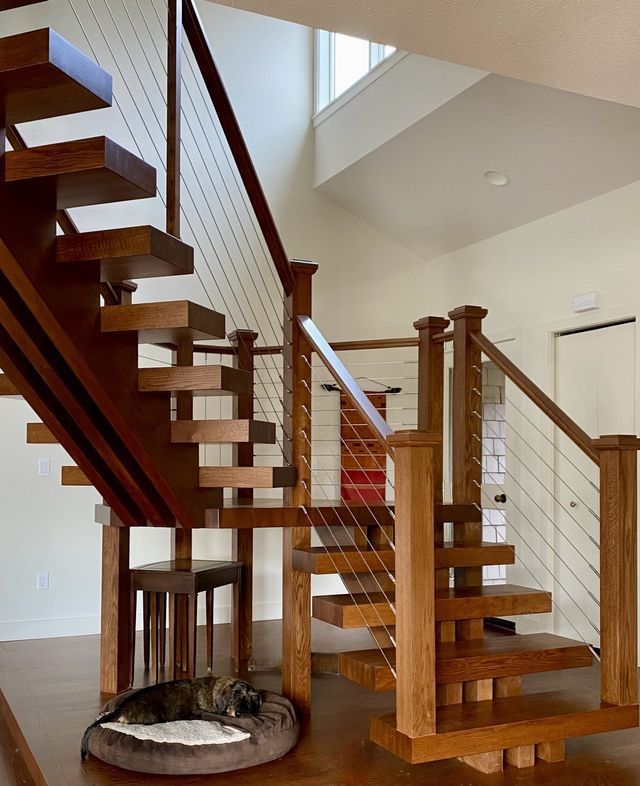 a cat is laying on a bed under a wooden staircase