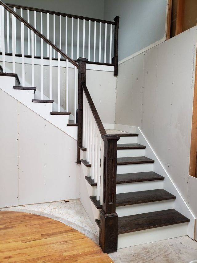 a staircase with wooden steps and a white railing in a room .