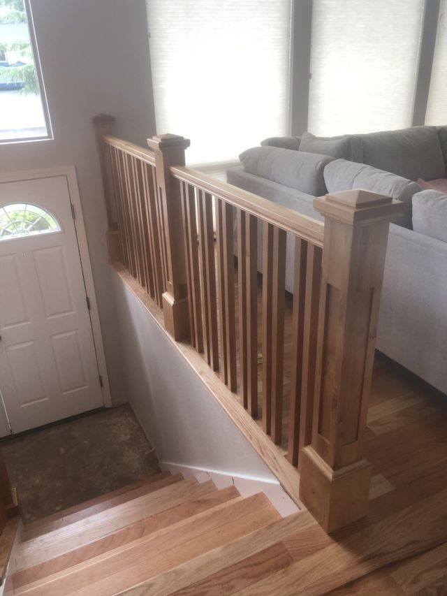 there is a wooden railing on the stairs in the living room .