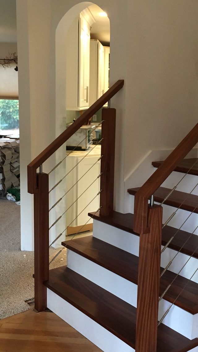 a wooden staircase with white steps and a metal railing