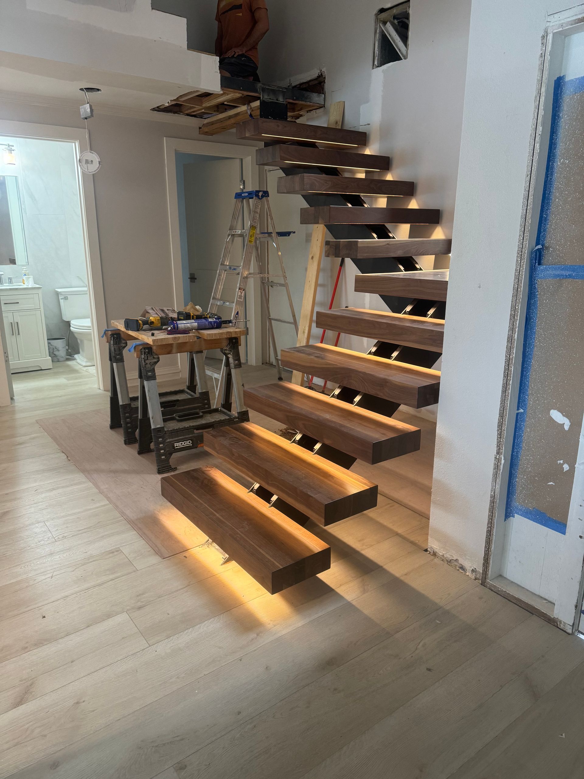 A wooden staircase is being built in a house.