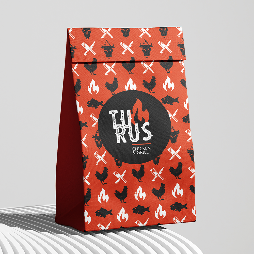 Um saco de papel vermelho com galinhas e peixes nele