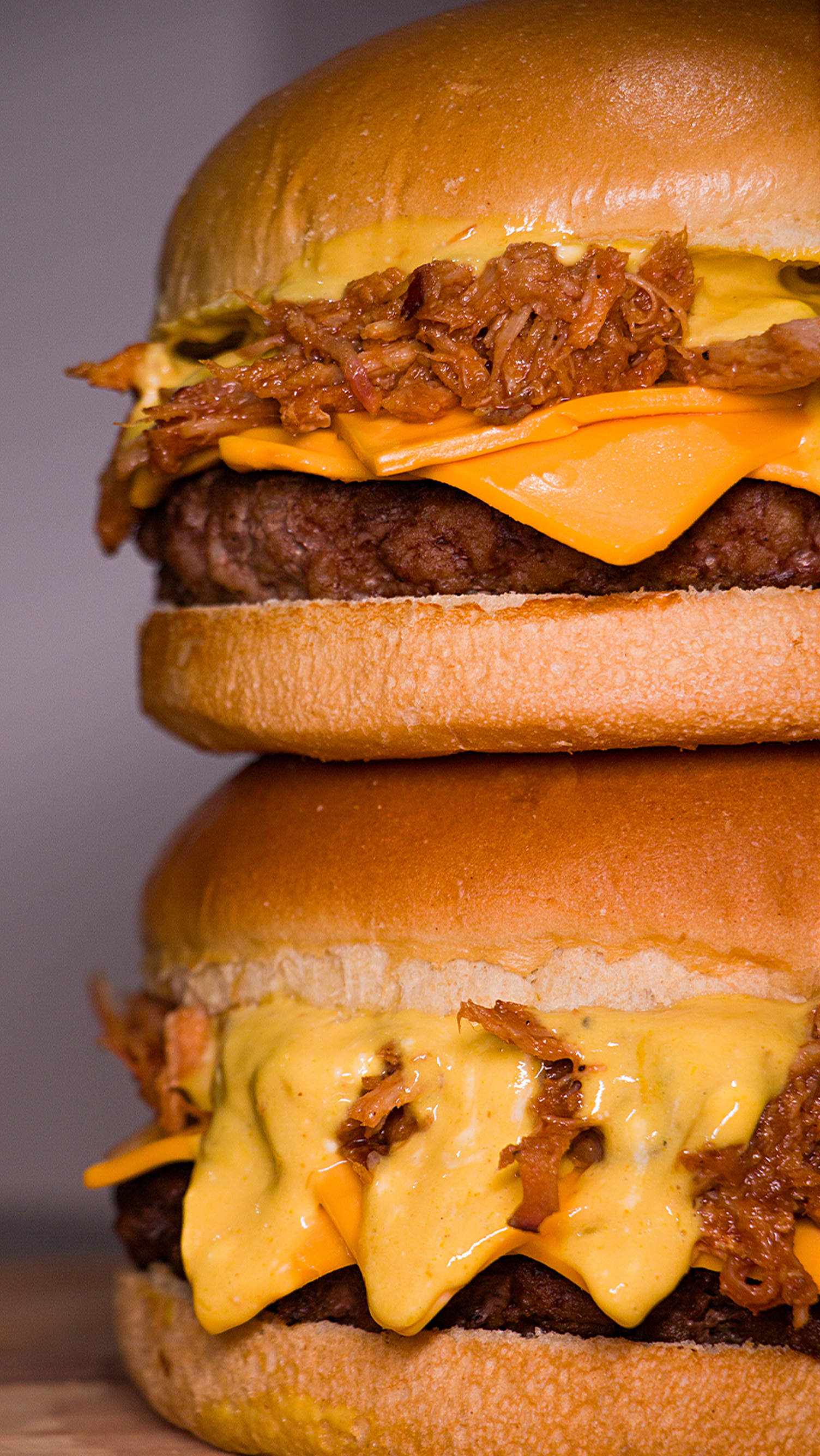 Um homem está segurando um hambúrguer na frente de uma multidão de pessoas.