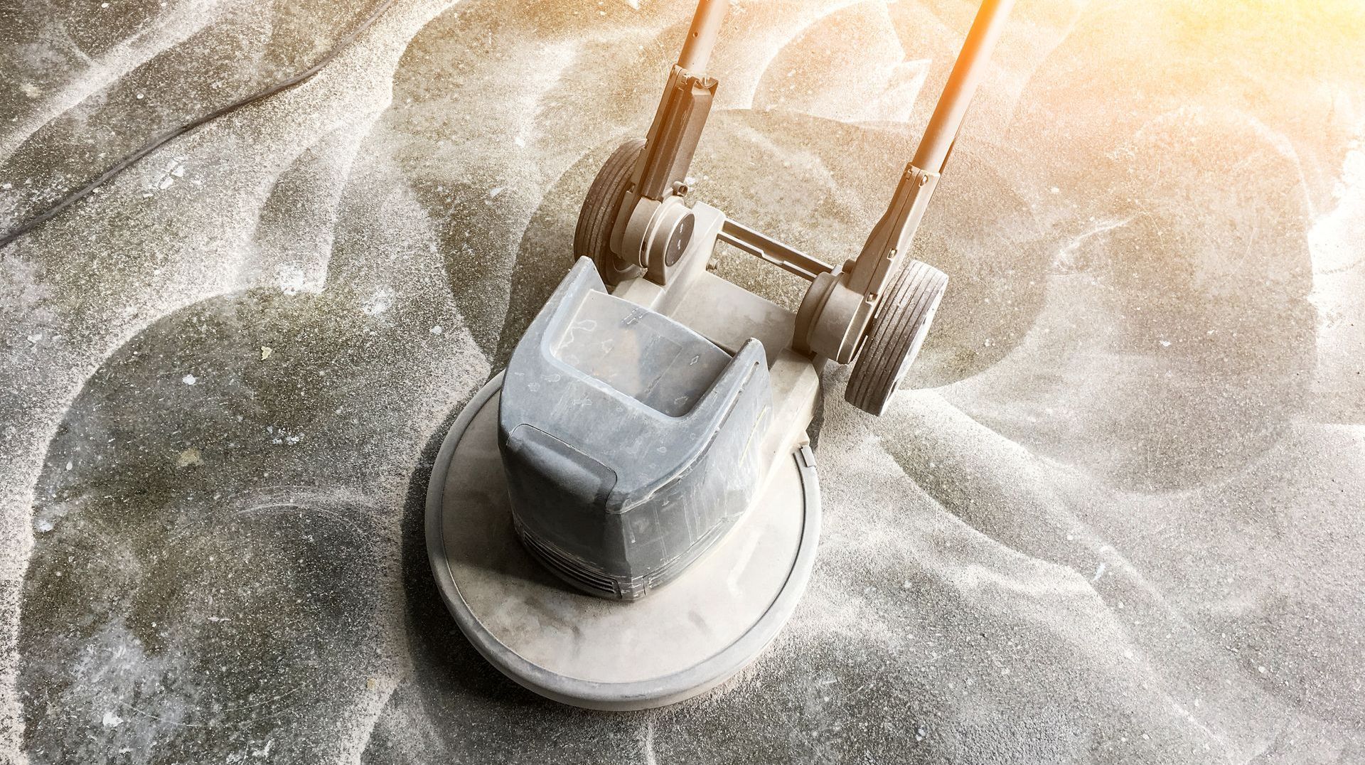 Une tondeuse à gazon est posée sur un tas de sable.