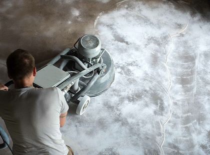 Un homme utilise une machine pour polir un sol en béton.