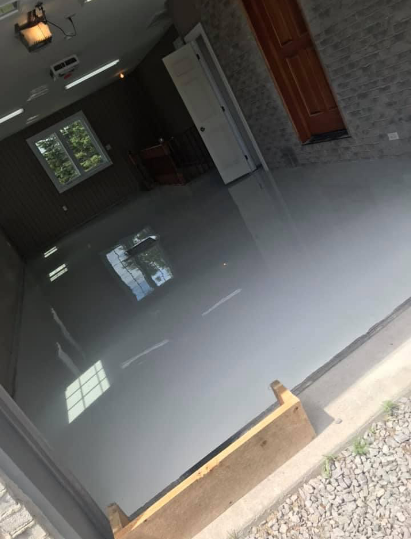 Un garage avec un sol en béton et un mur de briques.