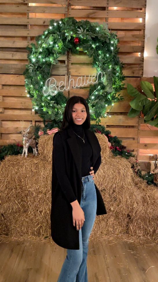 Dashanti standing and posing in front of haystack and Wreath.