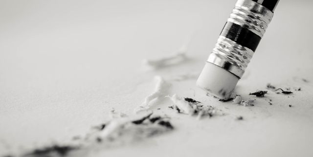 A black and white photo of a pencil erasing a piece of paper.
