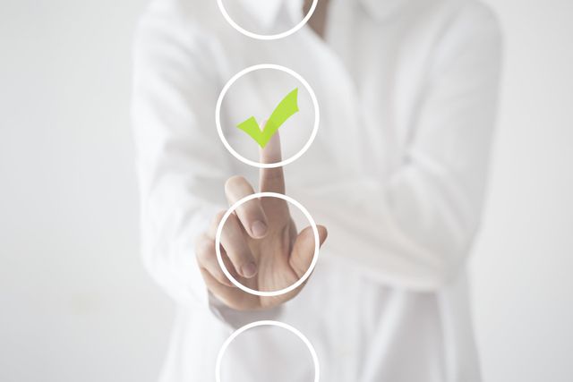 A person is pressing a button with a green check mark on it.