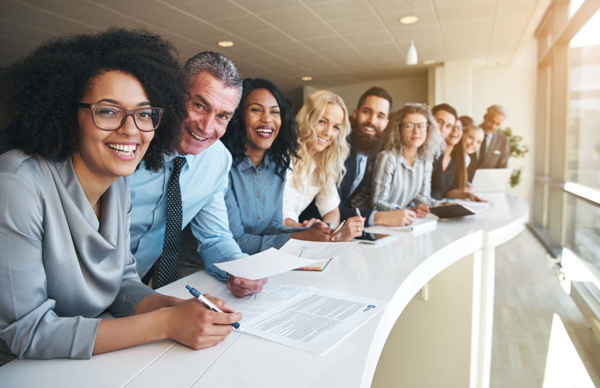 A group of people are sitting at a table in a conference room.