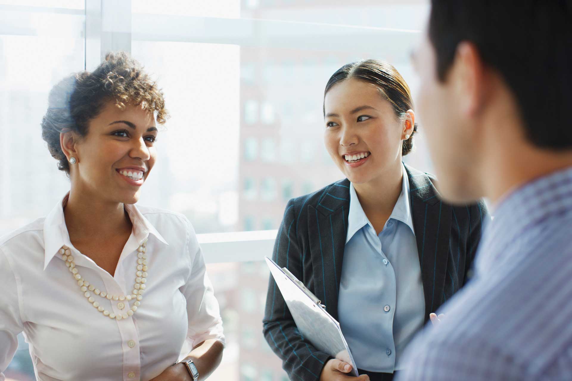 A group of business people are talking to each other in an office.