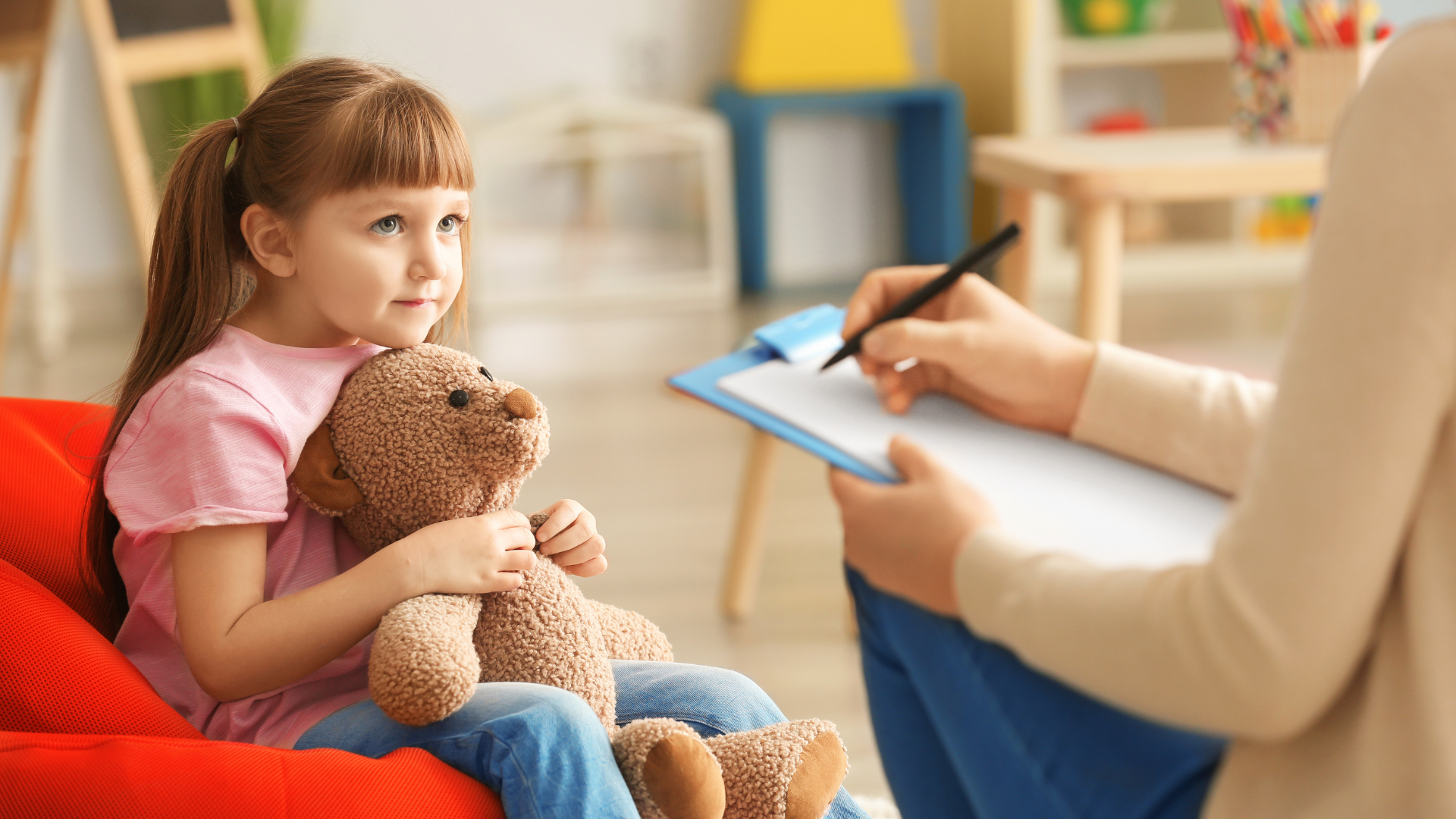 A nurse is bandaging a child 's leg on a mat.
