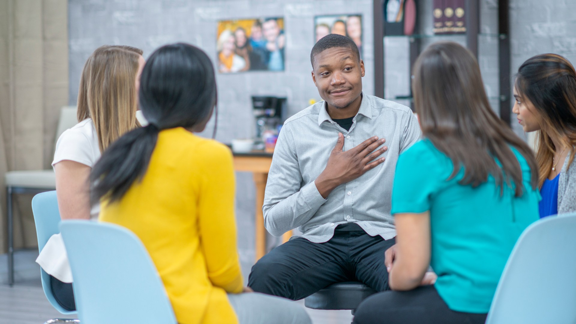 A group of people are sitting in a circle talking to each other.