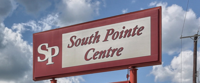 A car is parked in front of a sign that says south pointe centre