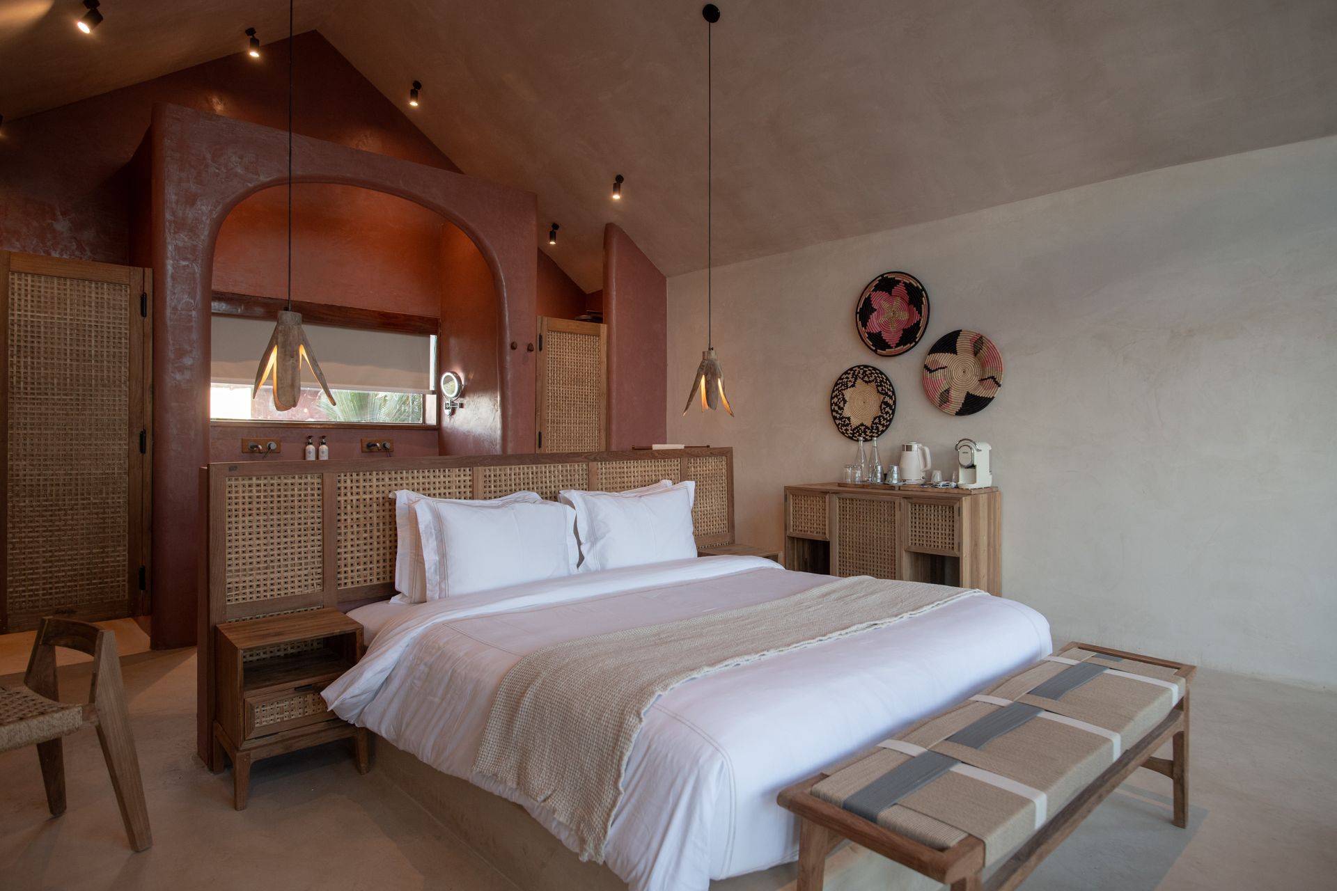 Bedroom with bed, desk, and TV; light wood furniture, pink walls.