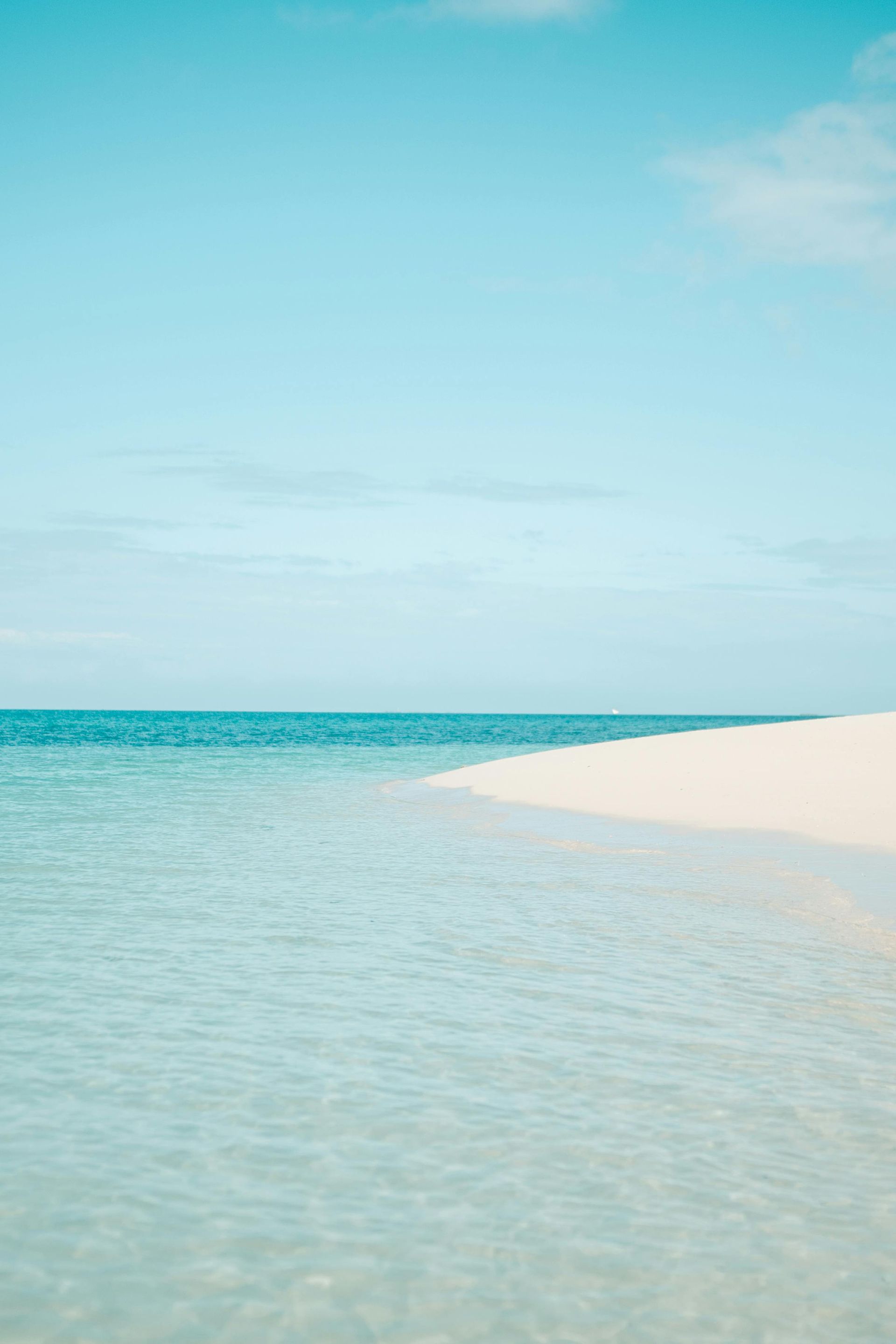 There is a small sandy island in the middle of the ocean.