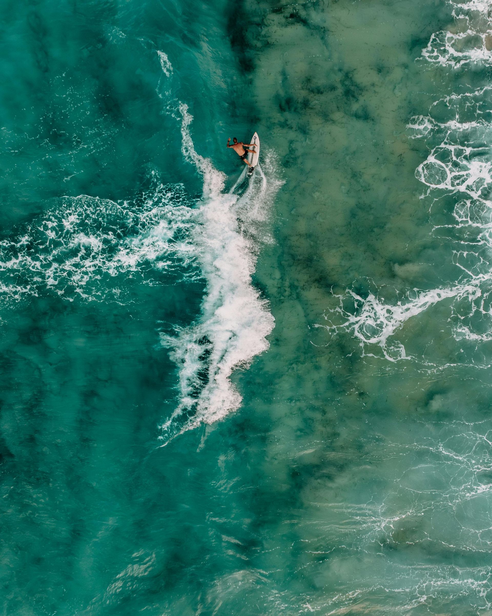 A woman is flying a kite in the ocean.